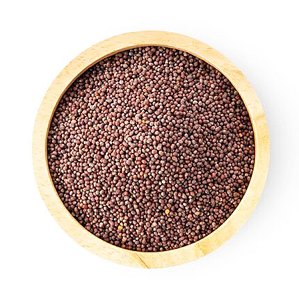 Top view of small round reddish-brown mustard seeds filling a light wooden bowl on a white background
