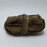 Tied bundle of dark brown fibrous siwak strands on a white background