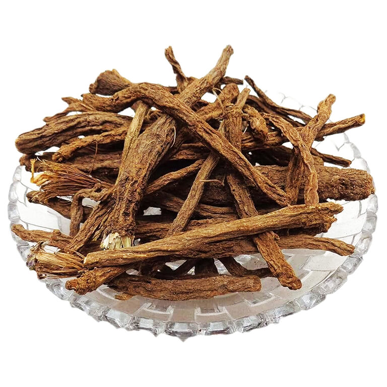 Long, wrinkled brown dried anacyclus roots, some with pale fibrous crowns, piled on a clear cut-glass dish