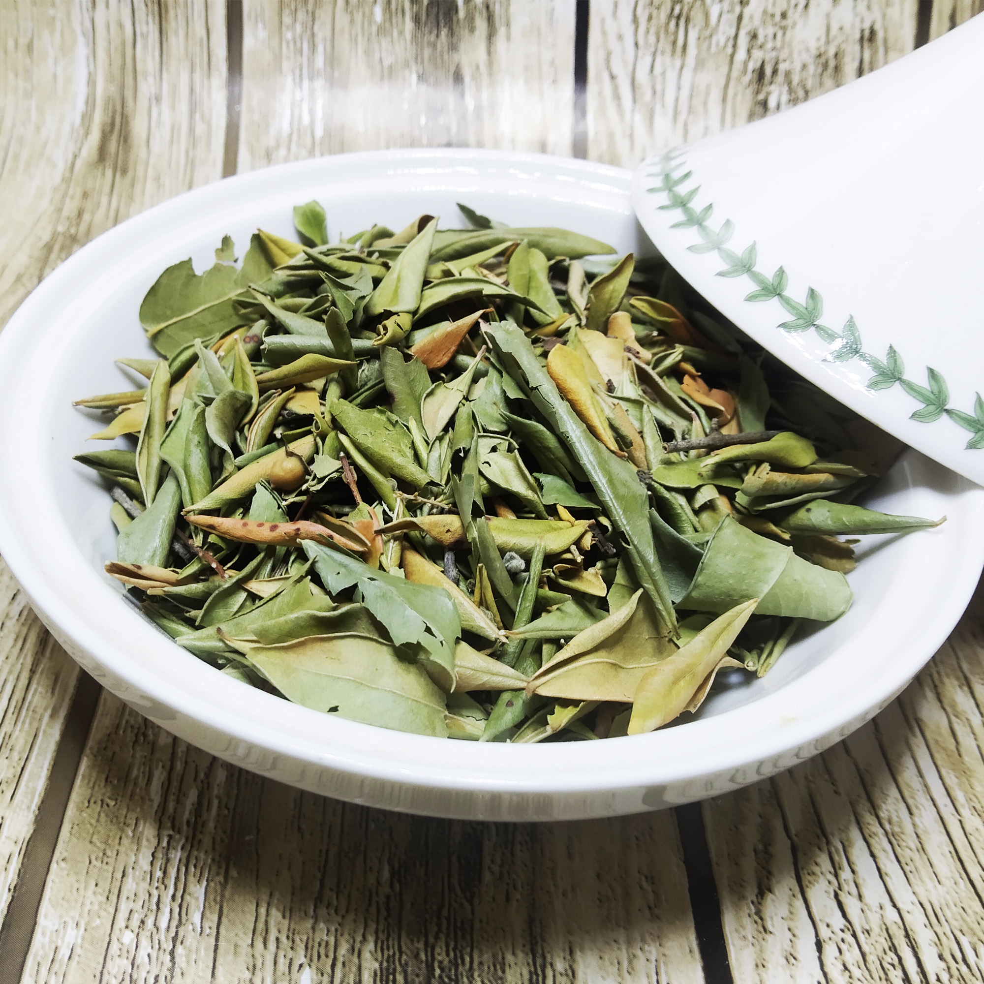 001-moroccan-basil-leaves-variation Dried green basil leaves in a white bowl on a wooden surface