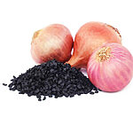 Pile of black onion seeds in front of three whole onions on a white background