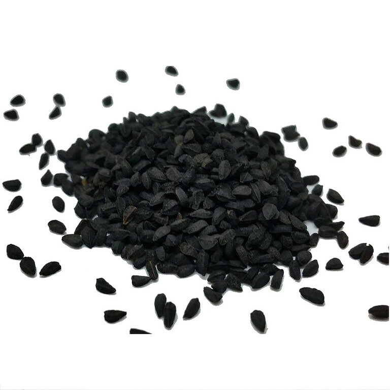 Loose matte-black black seeds scattered around a pile on a white background