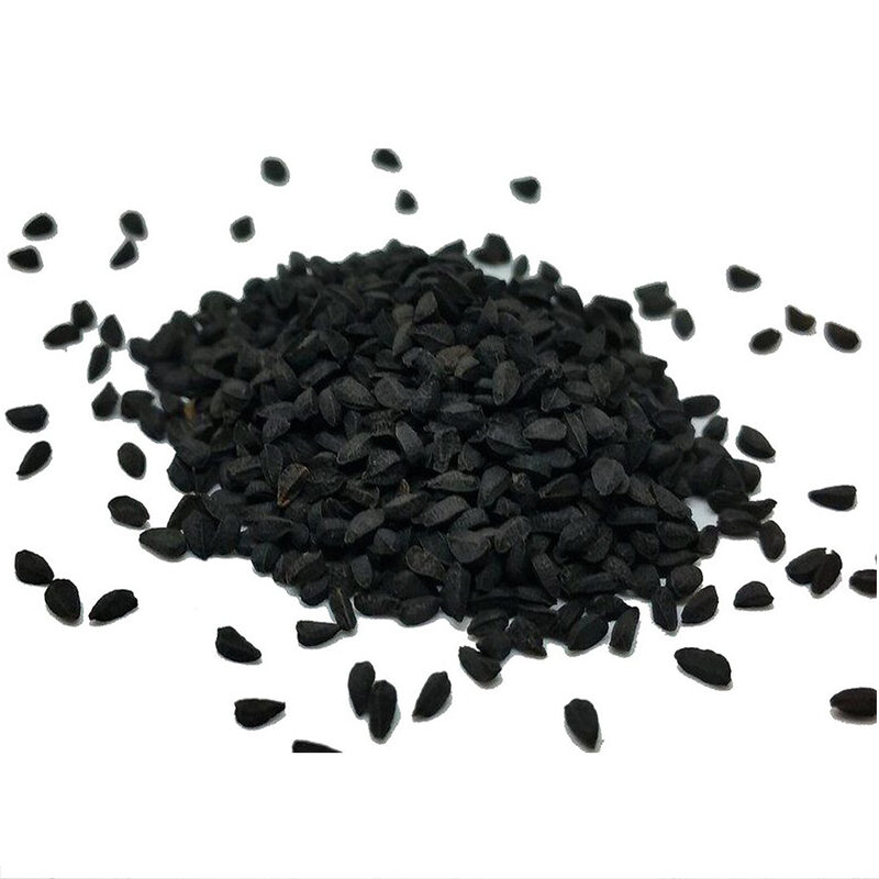 Graines de nigelle noires mates en vrac autour d'un tas sur fond blanc