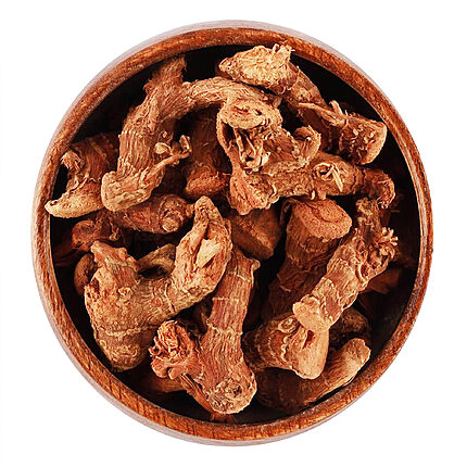 Knobbly reddish-brown pieces of dried galangal root heaped in a round wooden bowl, seen from above on a white background