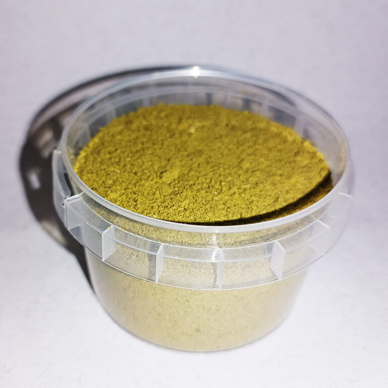 Open clear plastic tub holding fine green-gold herbal powder for hair.