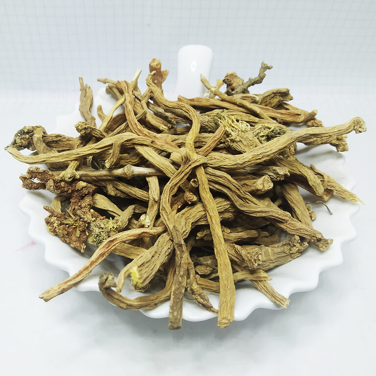 Pale beige fibrous dried Sarghina root pieces piled on a white scalloped dish.