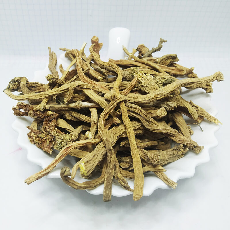 Pale beige fibrous dried Sarghina root pieces piled on a white scalloped dish.