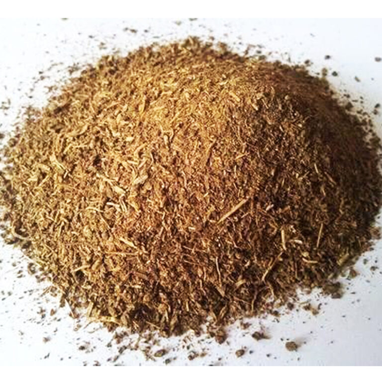 A loose mound of coarse tan-brown Indian costus root powder spread across a plain white surface.