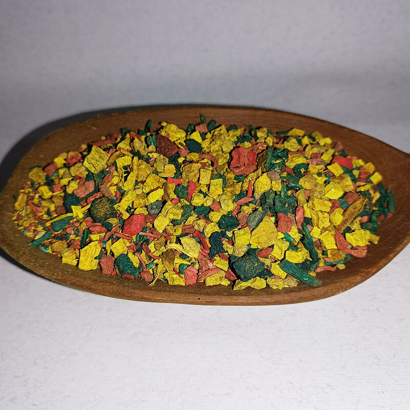 Colorful dry Sarghina bakhour pieces in a shallow wooden dish on a white background