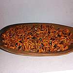 Wooden dish filled with orange, brown and black loose Zaghbat Alou incense pieces.