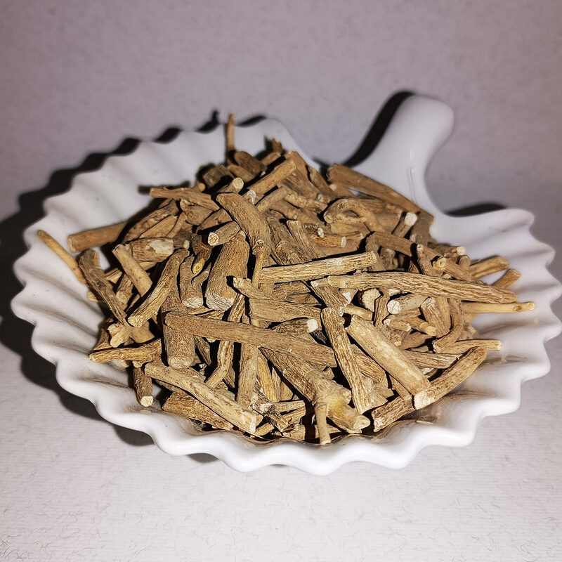 Light-brown dried ashwagandha root pieces in a white dish
