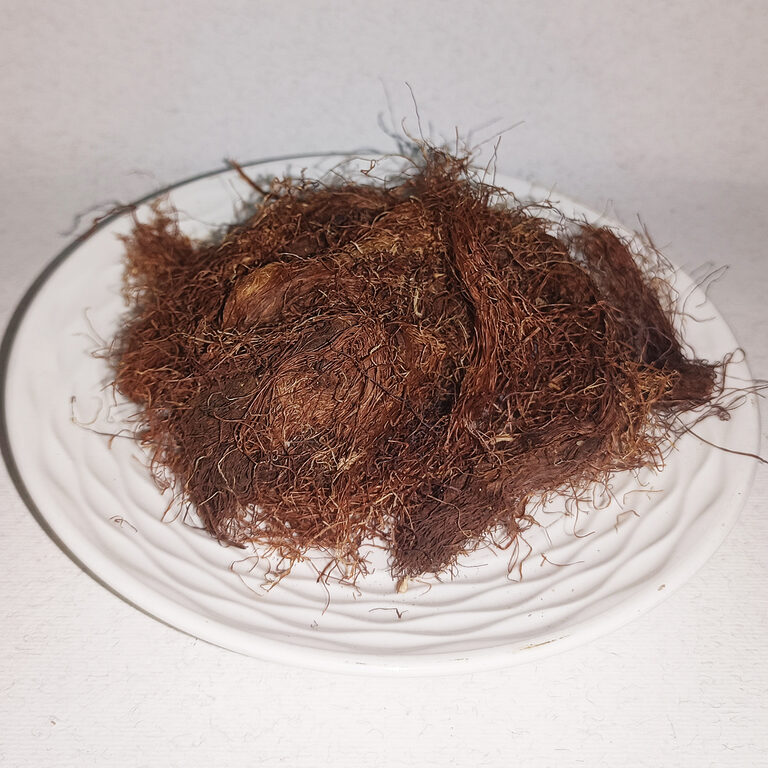 Fine reddish-brown dried corn silk fibres arranged on a white plate