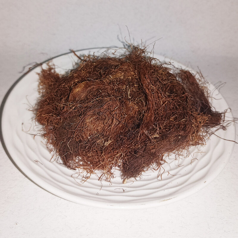 Fine reddish-brown dried corn silk fibres arranged on a white plate
