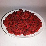 Deep red dried goji berries piled on a white plate