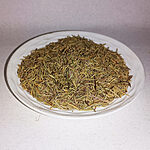 Dried rosemary needles and small stems piled on a white plate