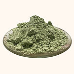 Pale green clay powder with natural clumps piled on a shallow dish