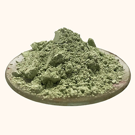 Pale green clay powder with natural clumps piled on a shallow dish