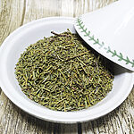 Chopped green dried juniper foliage and fine twigs in a white bowl