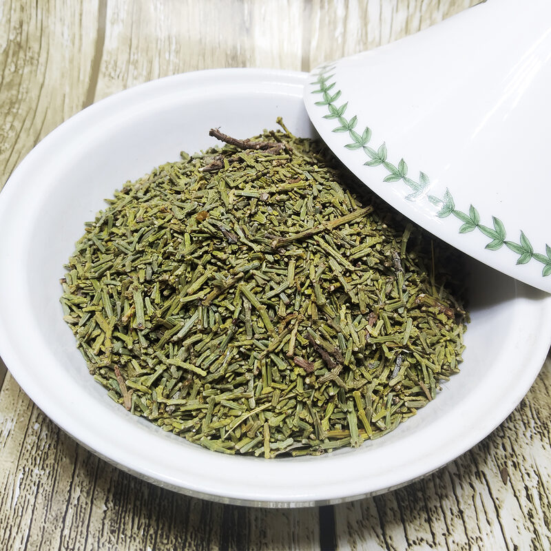 Chopped green dried juniper foliage and fine twigs in a white bowl