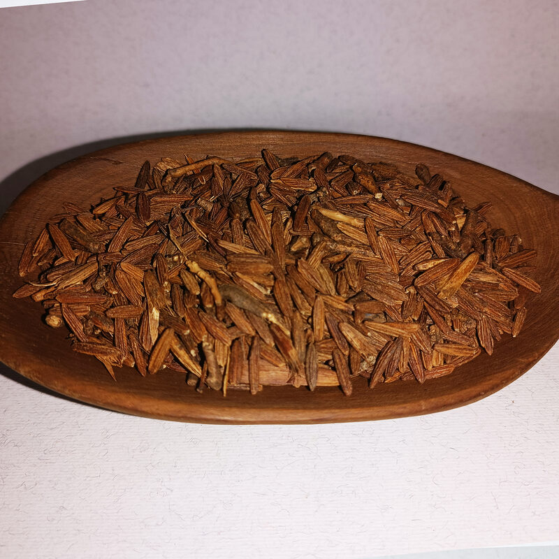 Loose brown fibrous Lissan Ettir dried herb in a wooden dish