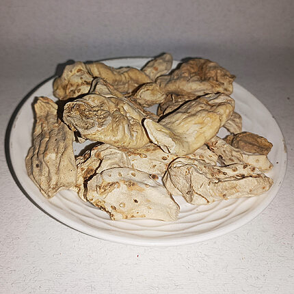 Pale irregular dried white amber pieces arranged on a white plate