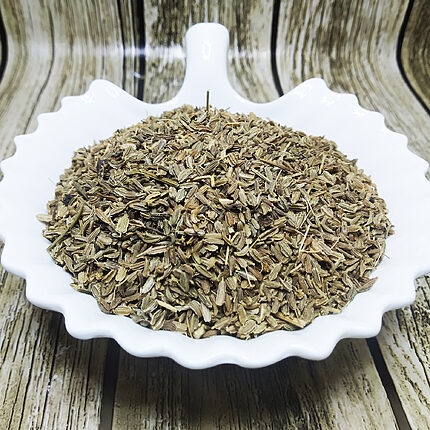Graines de carotte séchées en vrac dans un plat blanc sur une surface imitation bois