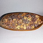 Mixed amber, honey, russet and dark resin pieces in a wooden dish