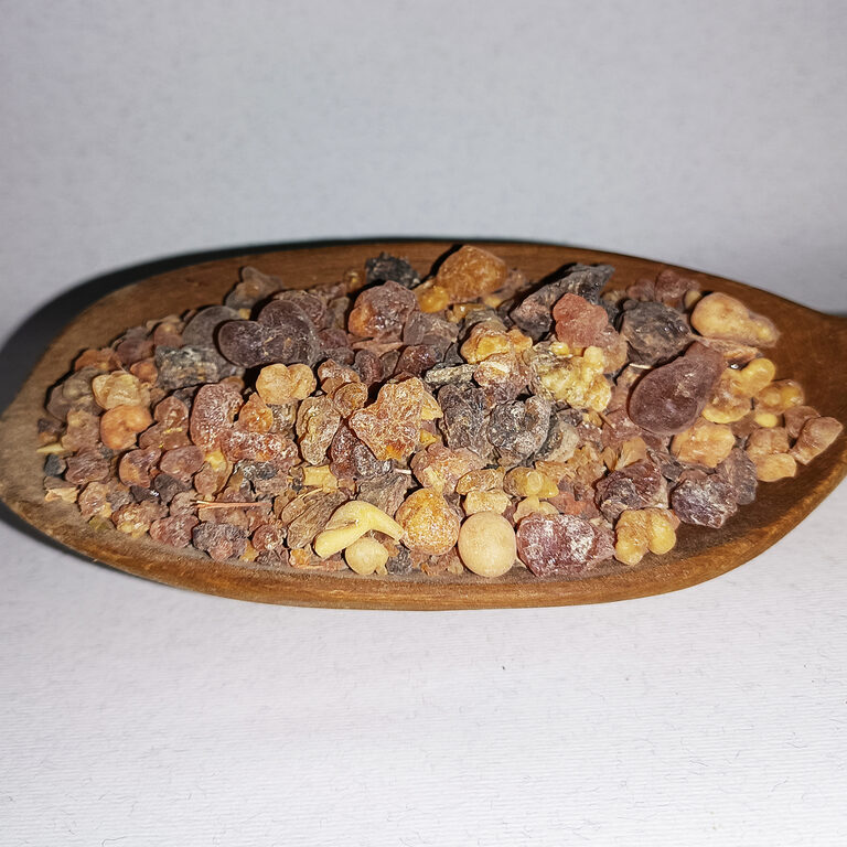 Mixed amber, honey, russet and dark resin pieces in a wooden dish