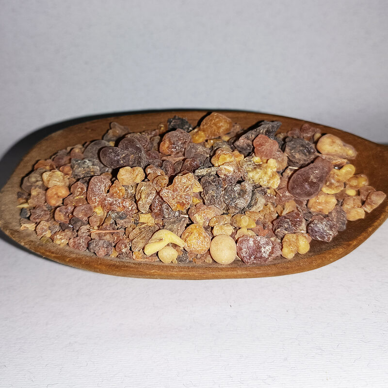 Mixed amber, honey, russet and dark resin pieces in a wooden dish