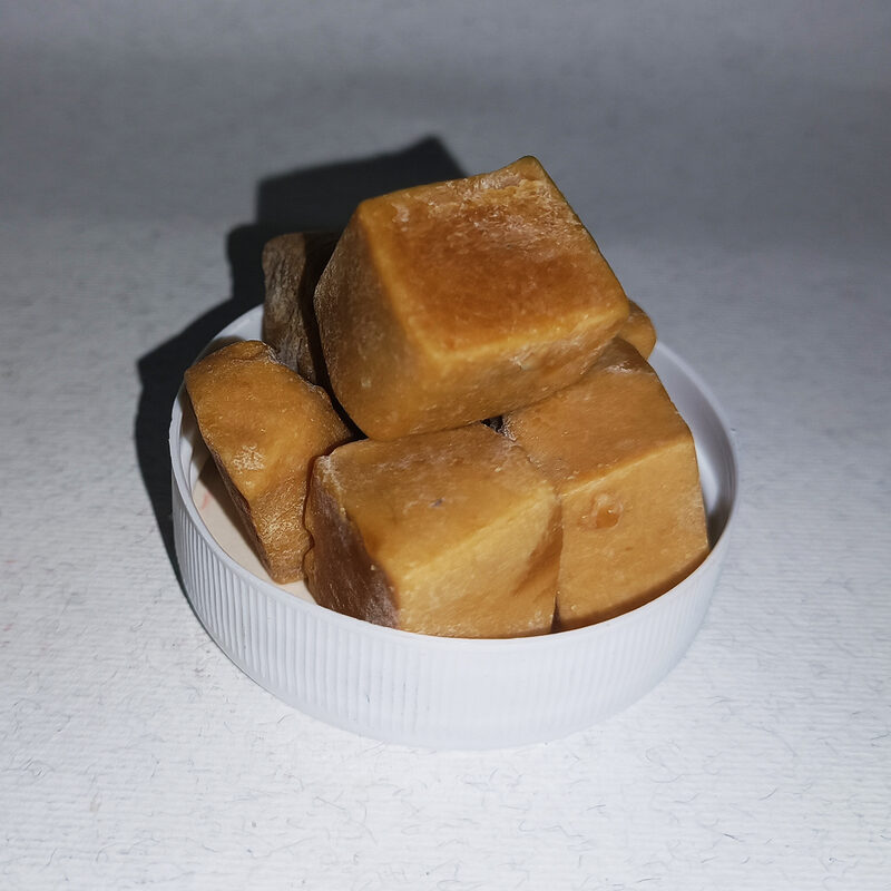 Amber-brown asafetida incense cubes arranged in a small white bowl.