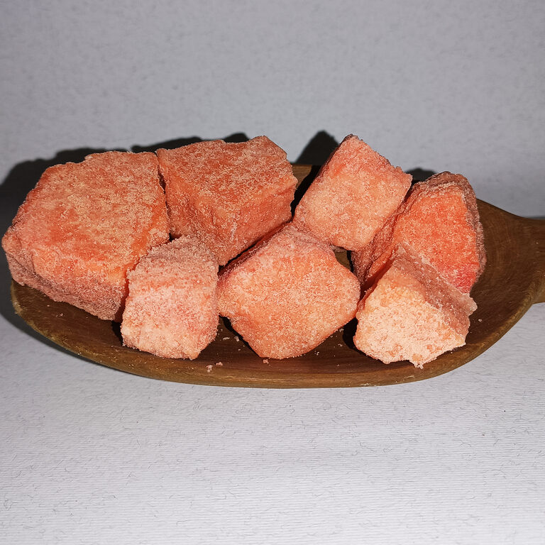 Rough peach-pink Yemeni alum stone pieces arranged on a wooden dish