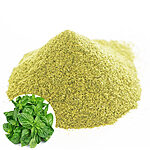 Mound of fine green basil powder on a white background with a basil leaf inset