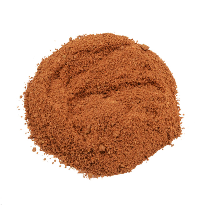 Close-up of a mound of fine reddish-brown Peganum harmala powder on a white background.